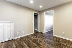 Spare room featuring dark wood-type flooring