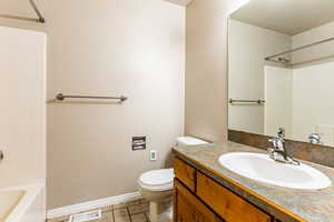 Full bathroom with tile patterned floors, vanity, toilet, and shower / tub combination