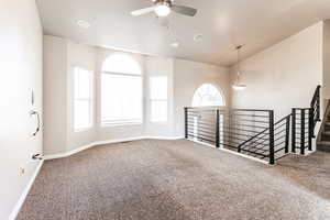 Unfurnished room featuring carpet floors, plenty of natural light, and ceiling fan