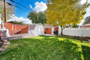 View of yard featuring a deck and a storage unit