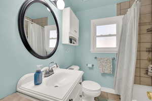 Bathroom with tile patterned flooring, toilet, and sink