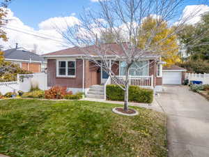 Single story home with a garage, an outdoor structure, and a front lawn