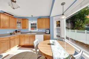 Kitchen featuring light tile patterned flooring, sink, white dishwasher, and pendant lighting