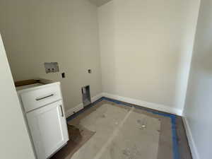 Laundry room with hookup for a washing machine, cabinet space, and baseboards