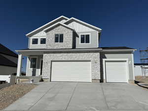 Craftsman-style house featuring driveway, an attached garage, fence, and board and batten siding