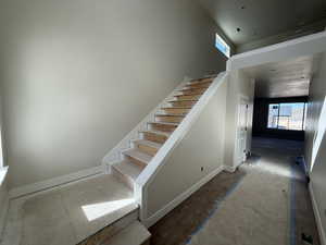 Stairway with baseboards and a wealth of natural light