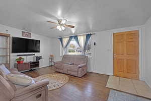 Living room featuring wood-type flooring and ceiling fan