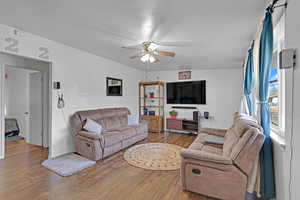 Living room with hardwood / wood-style floors and ceiling fan