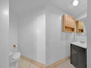 Bathroom featuring tile patterned flooring, vanity, and toilet