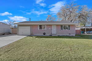 Single story home featuring a front yard and a garage