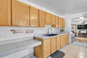 Kitchen with light tile patterned floors, ceiling fan, and sink