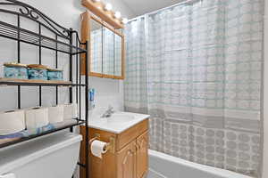 Bathroom featuring shower / tub combo with curtain and vanity