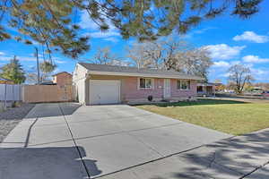 Single story home featuring a front yard and a garage