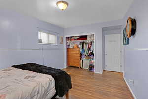 Bedroom with wood-type flooring and a closet