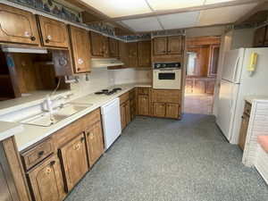 Kitchen featuring decorative backsplash, sink, and white appliances