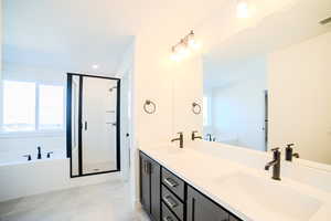 Bathroom featuring shower with separate bathtub, vanity, and tile patterned floors