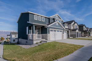 View of front of property with a front yard, a porch, central AC, and a garage