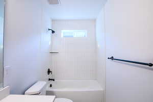 Full bathroom featuring vanity, toilet, and tiled shower / bath