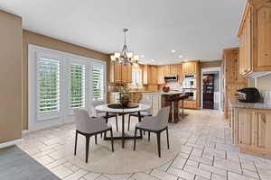 Tiled dining area featuring a notable chandelier