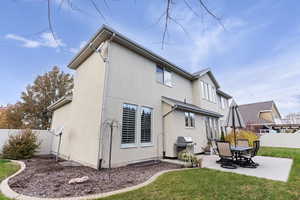 Back of property with a patio area and a lawn