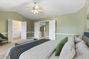 Bedroom featuring ceiling fan, light carpet, and vaulted ceiling