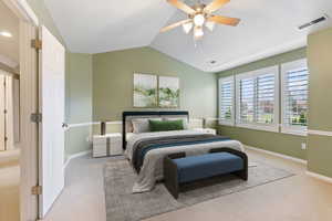 Bedroom featuring ceiling fan, light colored carpet, and vaulted ceiling