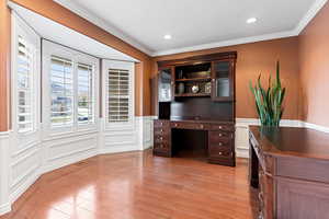 Home office featuring light hardwood / wood-style floors and crown molding