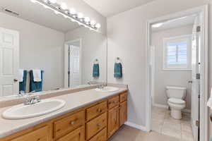 Bathroom featuring tile patterned flooring, vanity, and toilet