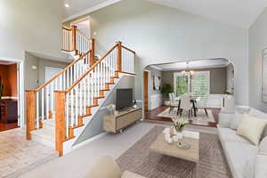 Living room featuring crown molding, light hardwood / wood-style flooring, and high vaulted ceiling