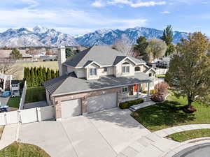 View of front of property featuring a mountain view, a garage, and a front lawn