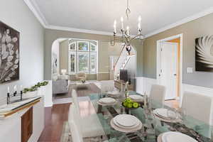 Dining space with a chandelier, hardwood / wood-style flooring, and crown molding