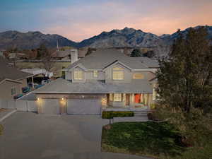 View of front facade featuring a lawn, a mountain view, and a garage