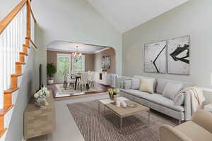 Living room with a chandelier, hardwood / wood-style flooring, high vaulted ceiling, and ornamental molding