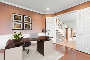 Office with hardwood / wood-style floors and ornamental molding