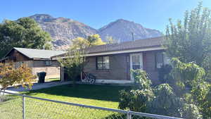 View of front facade with a mountain view and a front yard