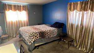 Bedroom featuring carpet and a textured ceiling