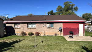 Rear view of property featuring a lawn and a patio