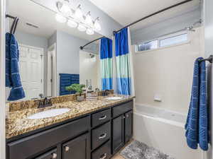 Bathroom with vanity and shower / bathtub combination with curtain