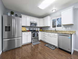 Kitchen featuring white cabinetry, and stainless steel appliances.