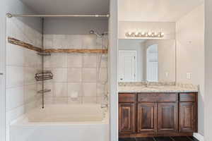 Master bathroom with vanity, tile patterned floors, and tiled shower / bath