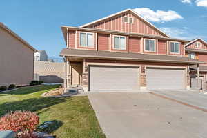 View of front of house with a garage and a front lawn