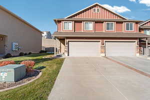 View of front of property featuring a front yard and a garage