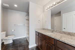 Master bathroom with tile patterned flooring, vanity, toilet, and shower / bath combination