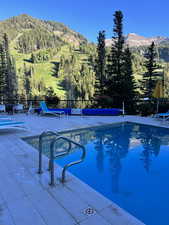 View of adult swimming pool with a mountain view and a patio