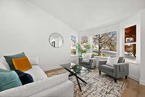 Living room with light wood-type flooring and lofted ceiling