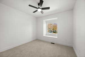 Carpeted empty room with ceiling fan