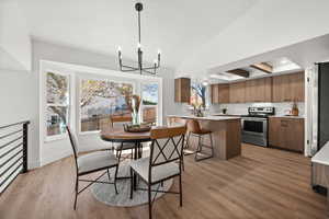 Dining area featuring plenty of natural light, an inviting chandelier, and light wood-type flooring