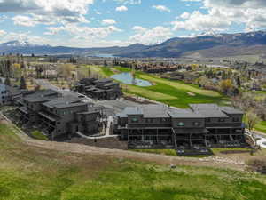 Birds eye view of property featuring a water and mountain view, view of golf course, and a residential view
