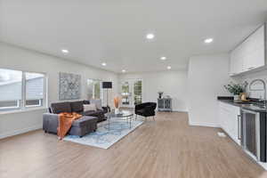 Living room with light wood-type flooring, sink, wine cooler, and french doors