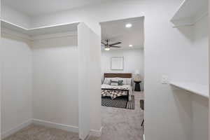 Walk in closet featuring light carpet and ceiling fan